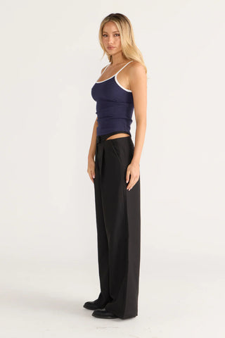 Woman in navy tank top and black pants, contrast look.