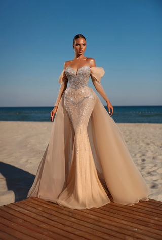 Woman in formal gown on beach.