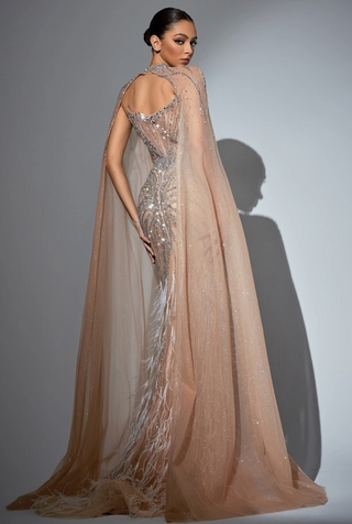 Woman in a long, beaded gown with a flowing cape.