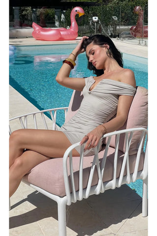 Woman in oyster off-shoulder dress by pool